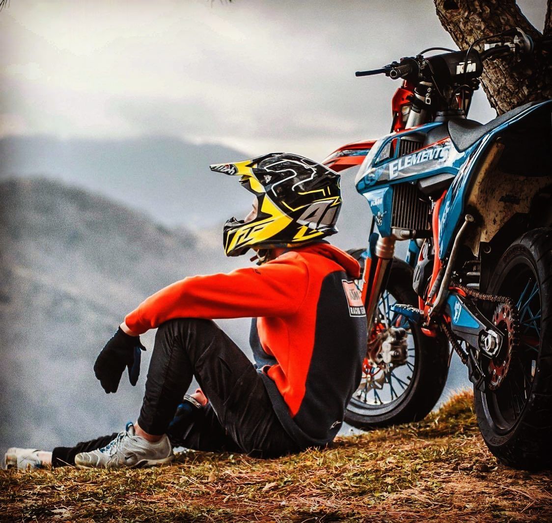 A man sitting on the ground next to his bike